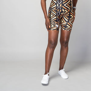 High-waisted biker shorts with a geometric pattern in black, brown, orange, and white colors, featuring two side pockets.